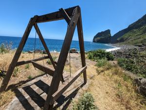 a wooden swing bench overlooking a body of water